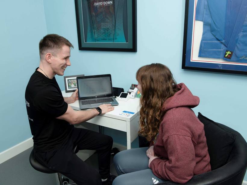 A therapist talking through an assessment with a client at Milton Keynes Sports Therapy.
